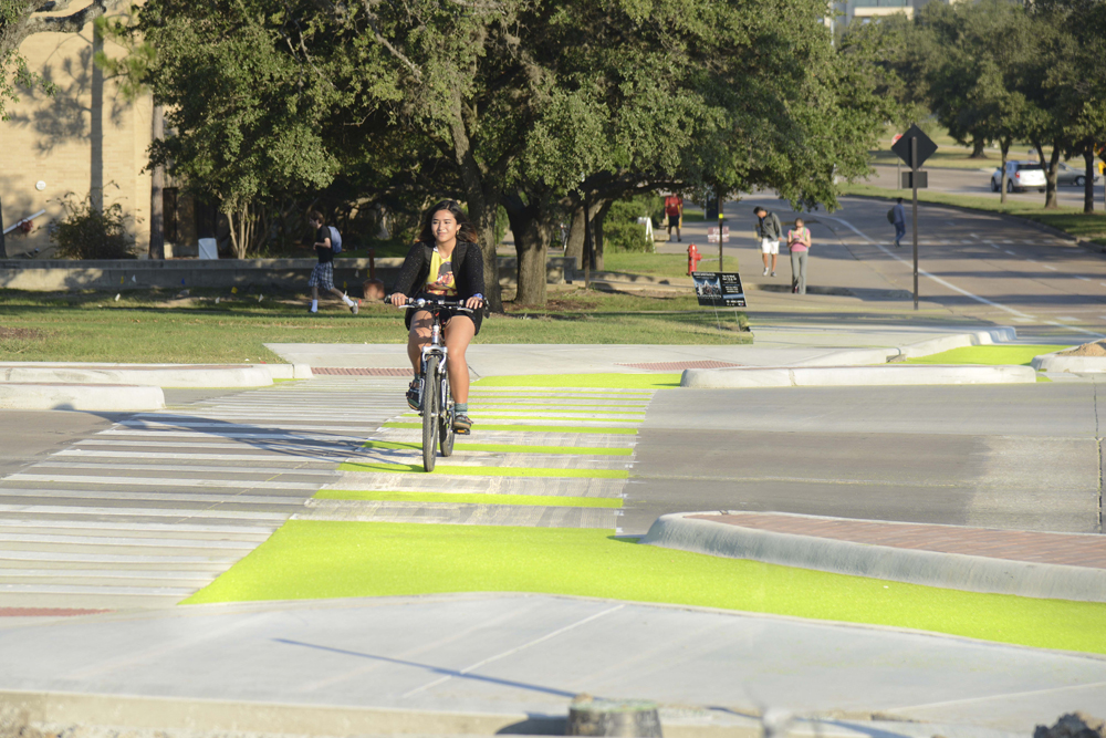 A bicyclist rides over the newly-installed solar bike lanes on the Texas A&M University campus.